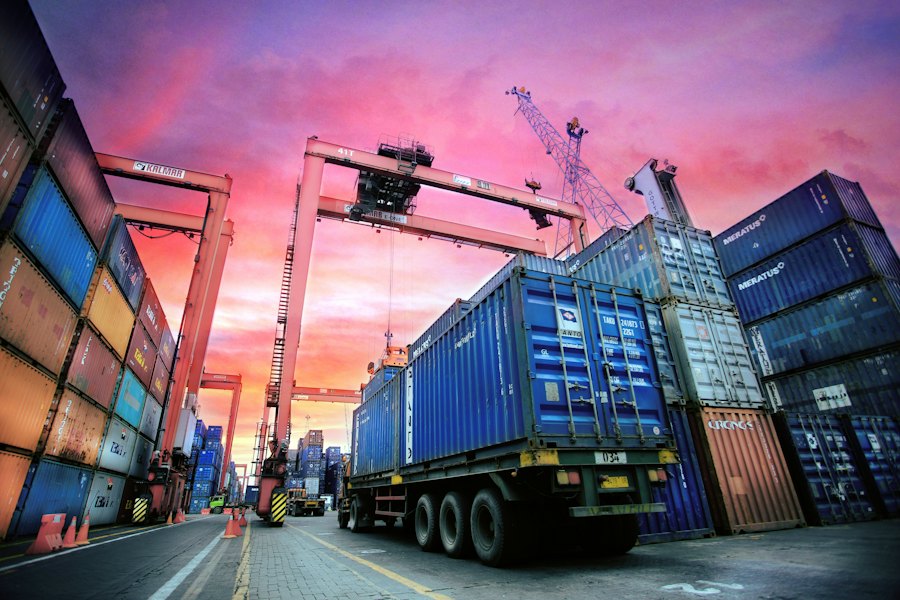 Container port with cranes at sunset